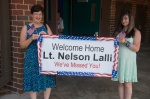Dorie and Chelle hold the Welcome Home banner before entering the gym.